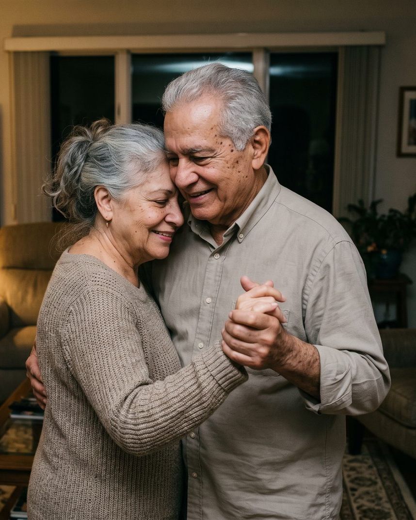 An older couple slow-dancing in their living room